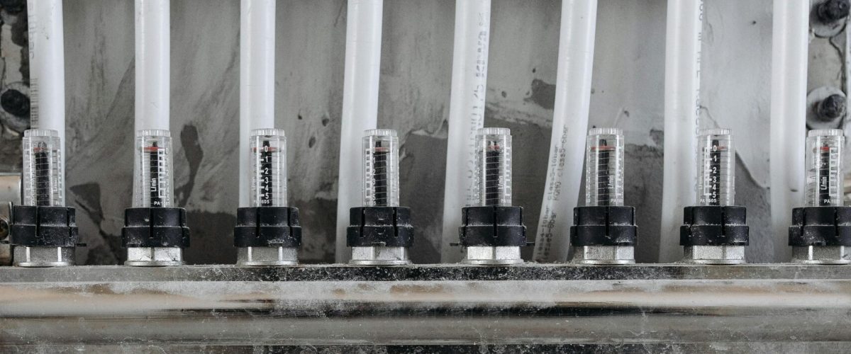 Close-up view of an industrial pipe connection system with pipe clamps, gauges and valves, to showcase what are pipe clamps.